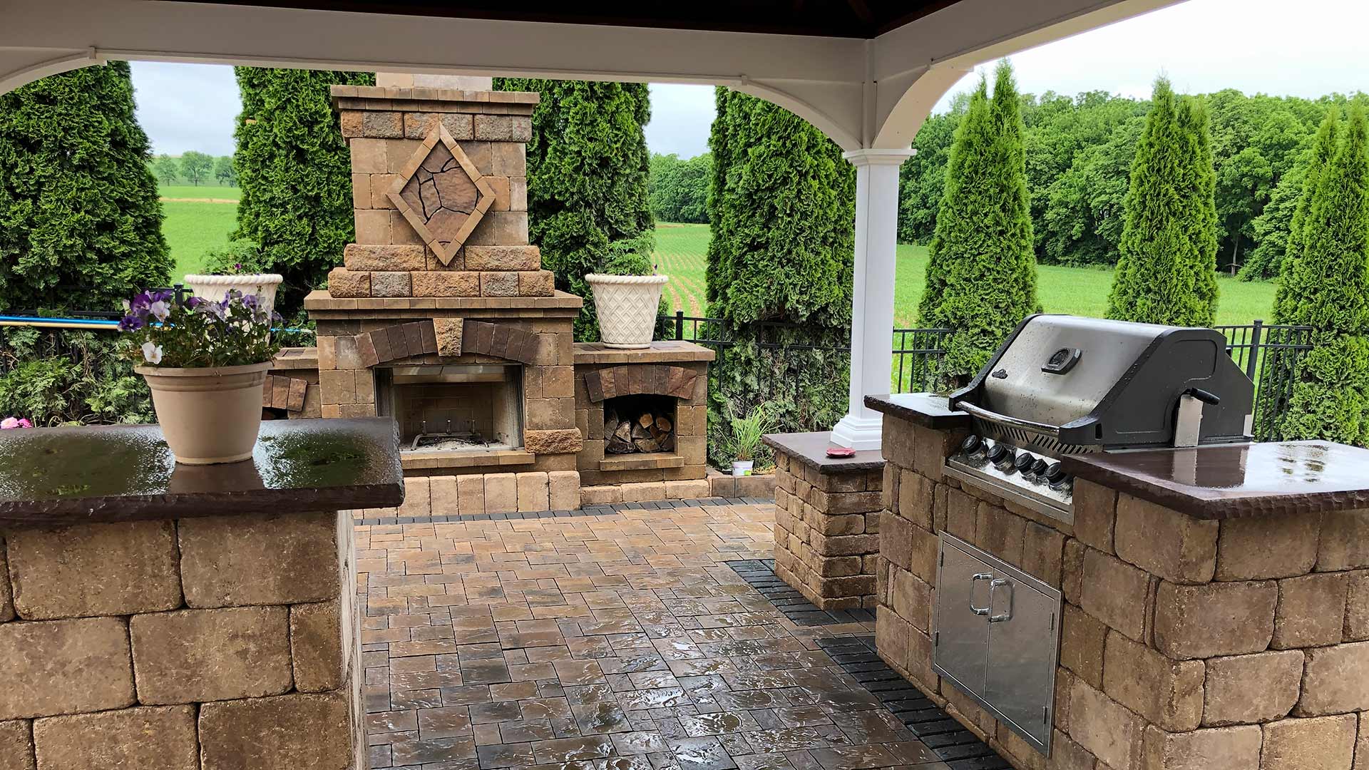 Beautiful outdoor living space with custom patio, outdoor kitchen, and fireplace near Clifton, NJ.
